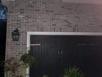 The brick face above the garage doors, the repaired cracks no longer visible.