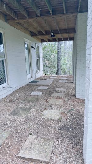 The finished area beneath the deck, gravel and stepping stones laid back over the work along the back wall.