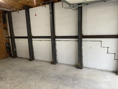 A basement wall bowing inward under soil pressure.