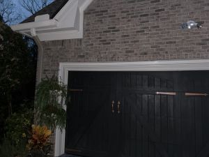 The detached brick garage from the side, the brickwork continuous above the doors.