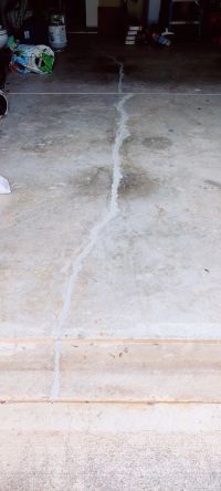 The wider garage floor, the sealed crack running out to the apron.