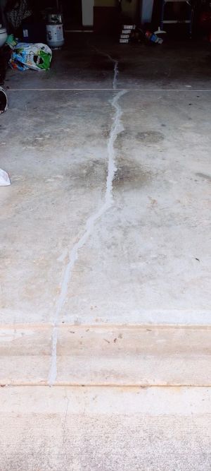 The wider garage floor, the sealed crack running out to the apron.