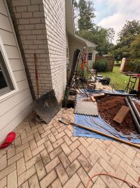 The wider patio, pump and pier tubes laid out on the tarp with the spoil pile beside them.