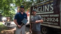 Two Anglin's crew members with tools and a clipboard, out on a free structural inspection.