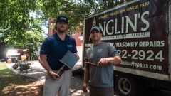 Two Anglin's crew members with tools and a clipboard, out on a free structural inspection.