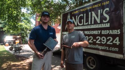 Two Anglin's crew members with tools and a clipboard, out on a free structural inspection.
