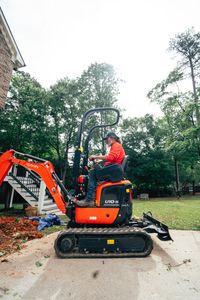 An Anglin's operator working the ground beside a Metro Atlanta home with a compact excavator.