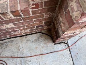 Before: the carport column separated from the concrete slab, an open expansion joint running along the base.
