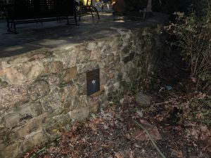 A second anchor plate further along the same wall, the patio and its furniture above.