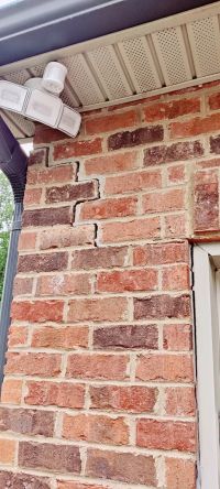 Before: a stair-step crack in the brick at the garage corner, running down from under the eave.