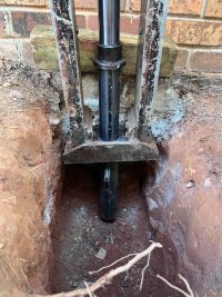 Looking down into the pier hole, the ram bearing against the footing under the column.