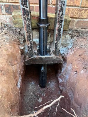 Looking down into the pier hole, the ram bearing against the footing under the column.