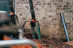 A driven steel pier installed beside a foundation wall, carrying the house on steel instead of soil.