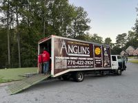 The Anglin's truck at the curb at dusk, ramp down and crew loading up.