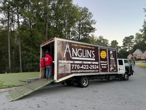 The Anglin's truck at the curb at dusk, ramp down and crew loading up.