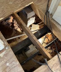 After: a steel beam carrying the joists on a new support and footing, the old block pier beside it.