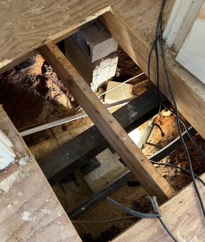 After: a steel beam carrying the joists on a new support and footing, the old block pier beside it.