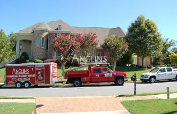 anglins truck with a trailer in front of a building being repaired