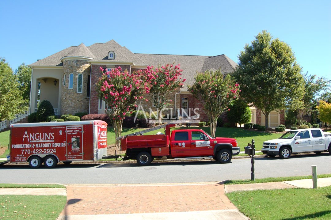 anglins truck with a trailer in front of a building being repaired