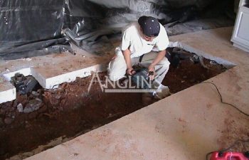 an anglin employee digging a hole in the ground for inserting a hydraulic pier