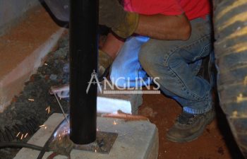 anglin's worker welding a pier supporting a sinking floor