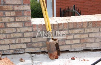 two shovels leaning on a wall
