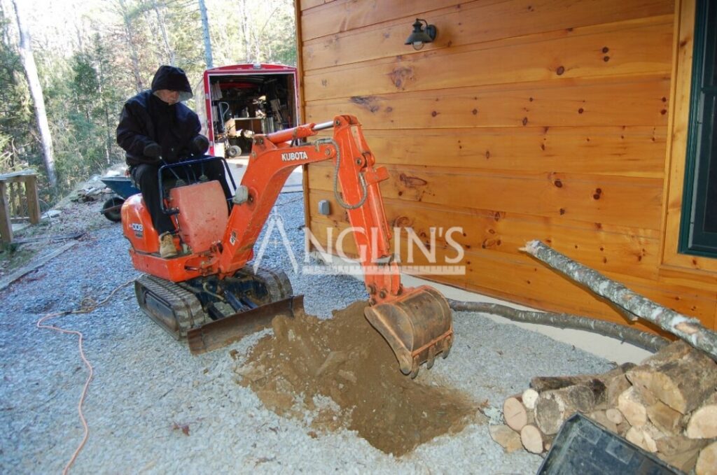 an anglin employee digging a hole with a mini excavator