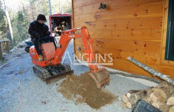 an anglin employee digging a hole with a mini excavator