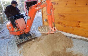 an anglin employee digging a hole with a mini excavator