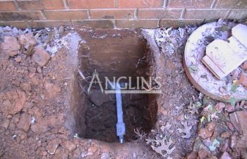 excavation with an anchor installed in a brick wall foundation