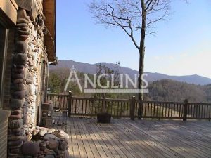 view of woods and hills from a decko belonging to a brick house