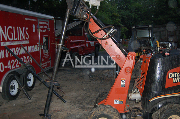 skid steer with a drill ready to dig into the ground