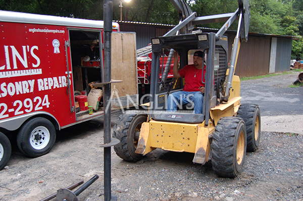 anglin employee in a skid steer digging a hole