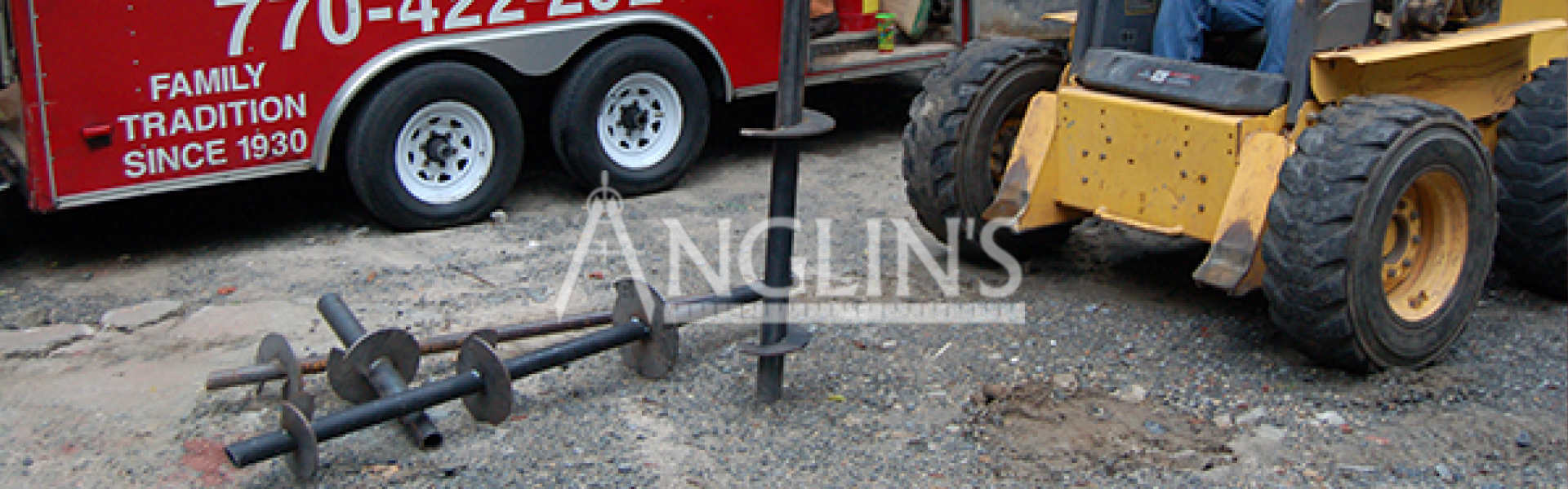 helical piers lying on the ground next to anglin's truck