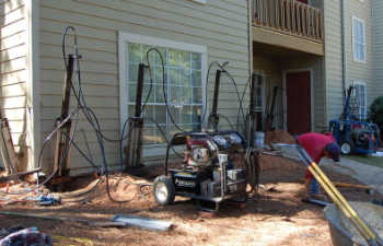 four hydraulic piers installed to support sinking house walls while repair